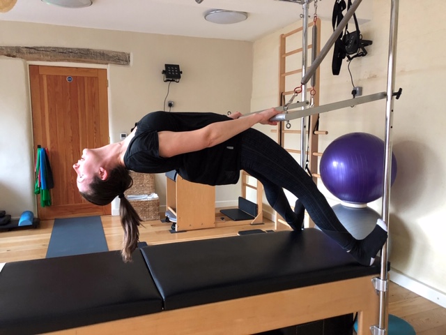 advanced pilates stretch on studio equipment 